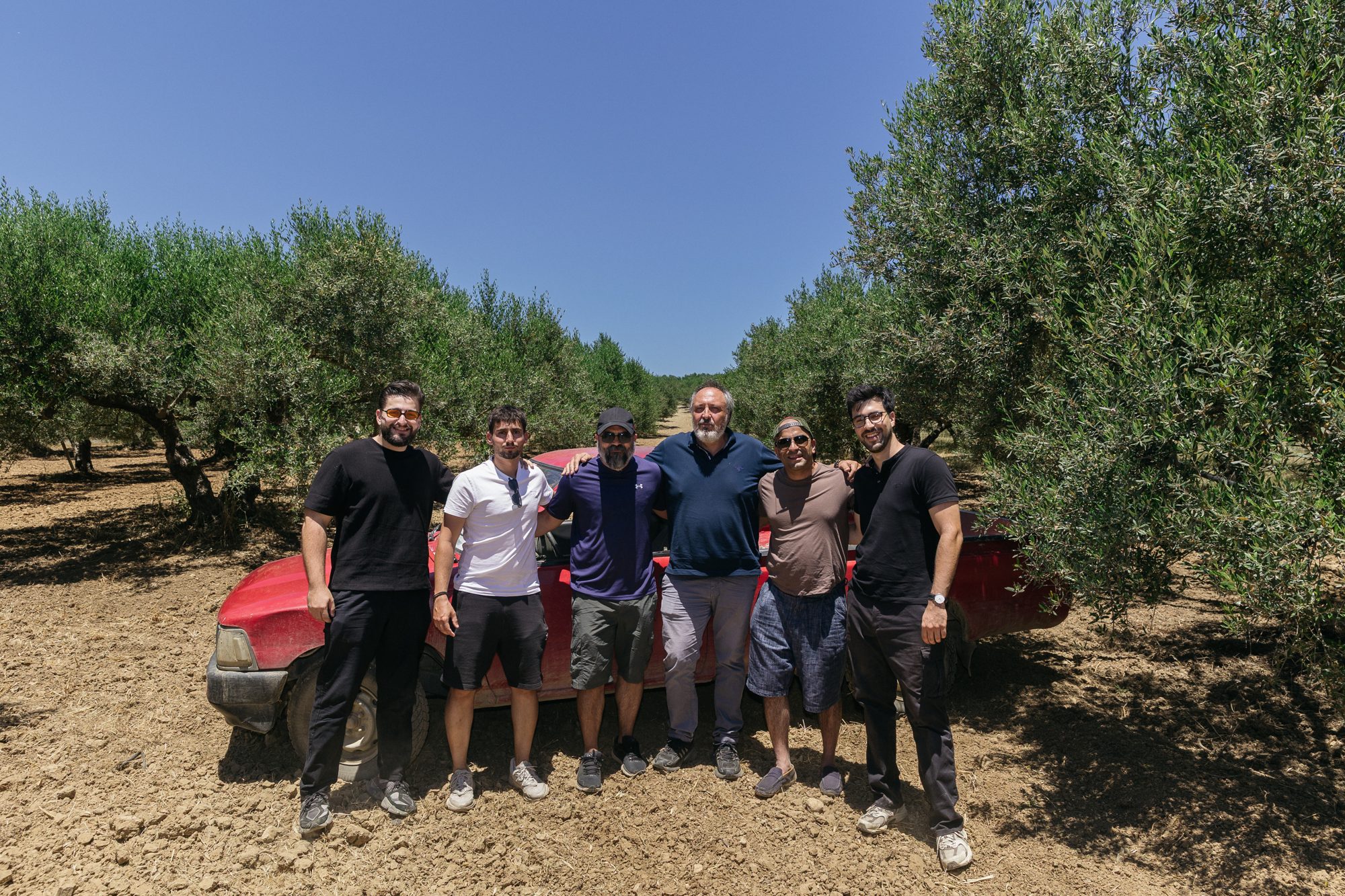 The Cretekos team in the olive groves with the estate truck — Chania, Crete